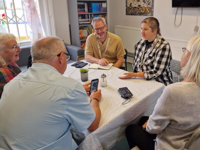 Group of people sitting around a table talking.