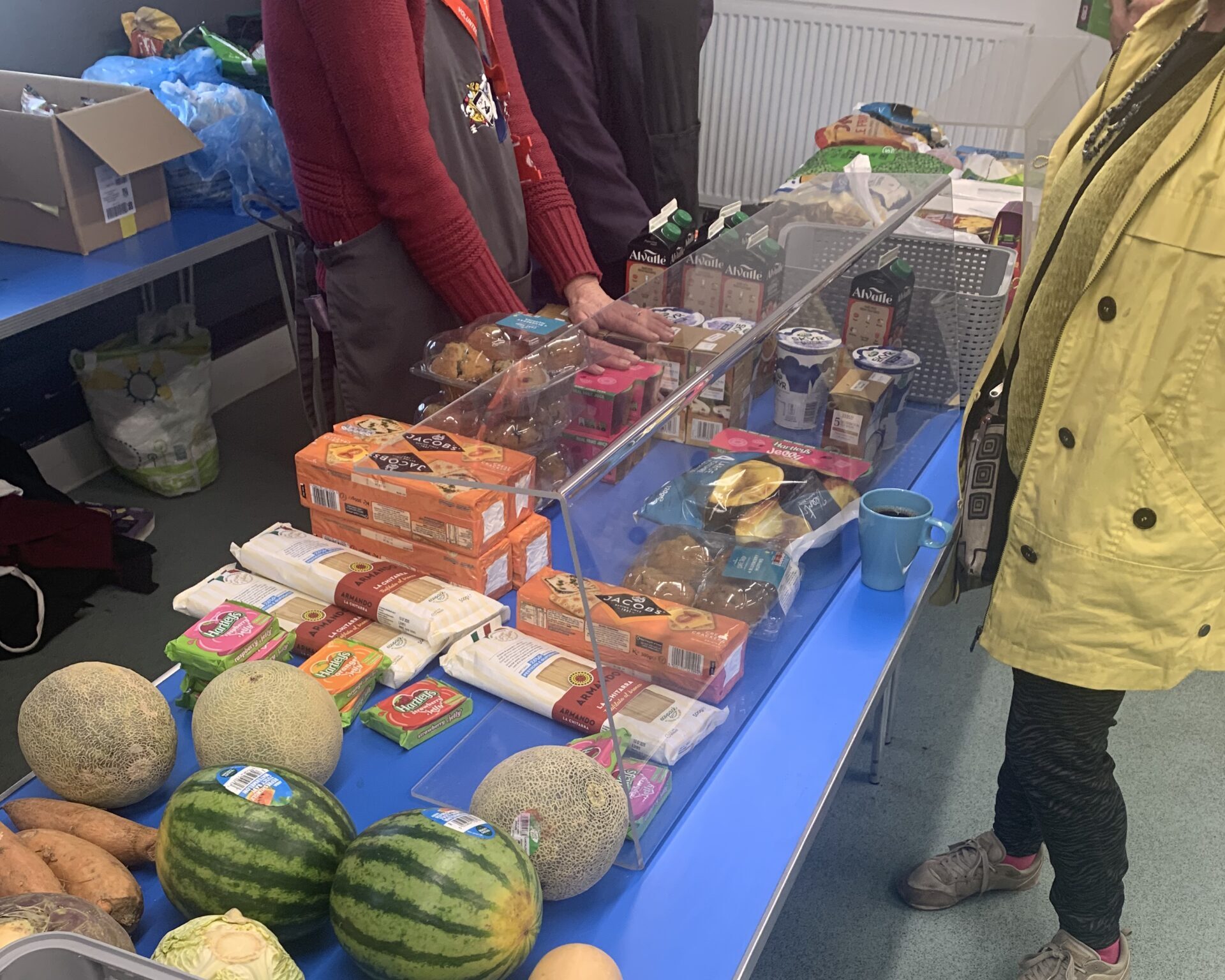 person at foodbank stall choosing food products.