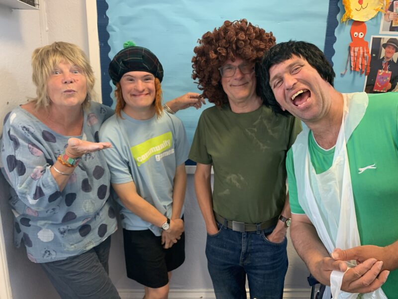 four people with wigs on laughing