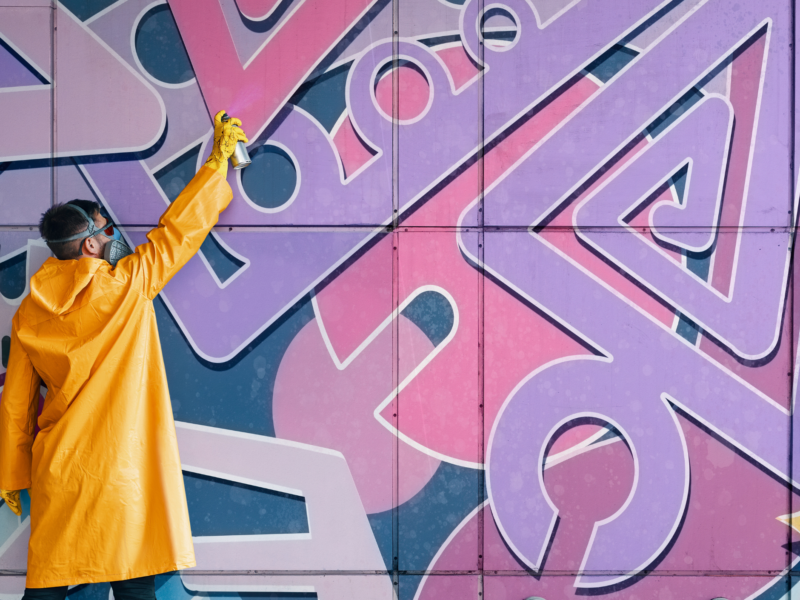 person painting mural on wall