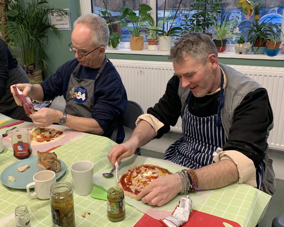 two attendees making pizza