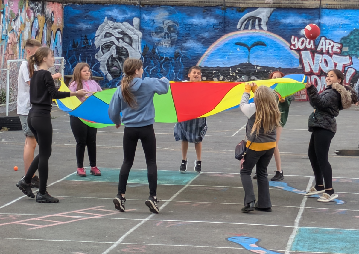 young people playing with parachute